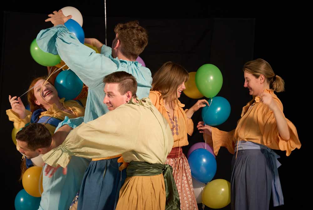 Menschengruppe mit Ballons auf der Bühne